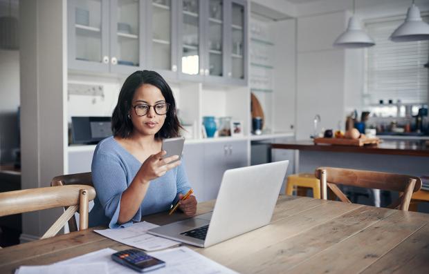 woman with phone and laptop making sure she is secure